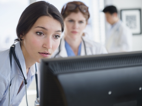 two physicians looking at monitor