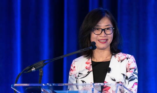 woman standing at podium smiling